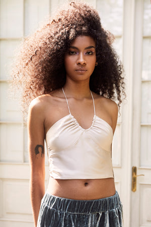 Abrir la imagen en la presentación de diapositivas, Ruched halter crop top featuring an ivory satin fabric and an open tie back. Team it with some cute pants!
